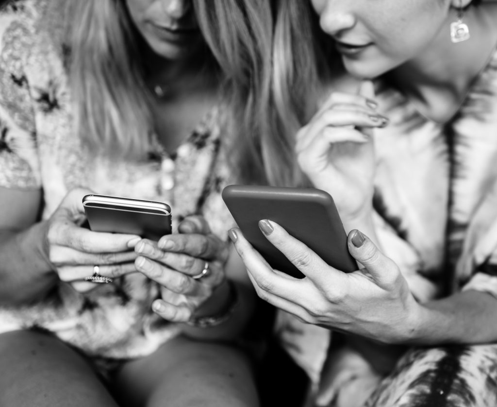 Girlfriends communicate and connected by mobile phone